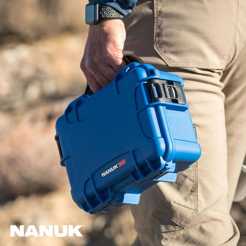 Freakishly Durable IP67 Waterproof Hard Shell Case Built For Tough Travel Days in blue held by a person outdoors.