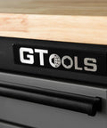 Close-up of ‘GT TOOLS’ logo on the drawer of Heavy Duty Steel Rolling Tool Chest With Fourteen Deep Full Extension Drawers And Massive Mega Top Tray For Garage Organization Grease Monkey Approved Workhorse Cabinet.