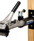 Deluxe Wall Mount Bicycle Repair Stand With 100-3C Clamp Powder Coat Finish on wooden post, shop quality construction.
