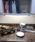 Lit LED Under Cabinet Light 24 Inch, 1200 Lumens Warm White 3000K Plug In illuminating a workbench with tools and books