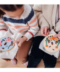 Two people using the All In One Bee Embroidery Kit For Beginners With Hoop And Thread, showcasing bee pattern cloths and threads.