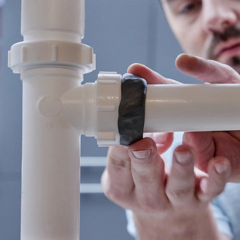 Person applying Two Ounce Epoxy Putty Stick That Delivers A Fast Hardcore Waterproof Bond For Cars Boats Plumbing And Home Repairs Cures Dark Gray Heat Resistant Up To 350 Fahrenheit Holds Four Tons Chemical And Fuel Resistant on pipe joint