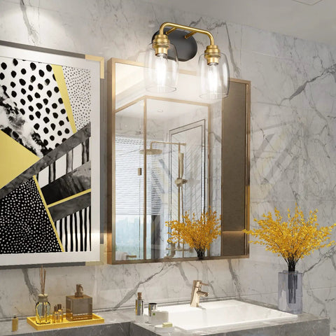 Two Light Sleek Industrial Black And Gold Vanity Light Fixture Over Mirror With Clear Glass Shades in modern bathroom