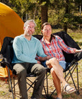 Couple seated on Two Person Oversized Camping Chair Loveseat For Adults Heavy Duty Folding Outdoor Couch Black Portable Patio Lawn Chair