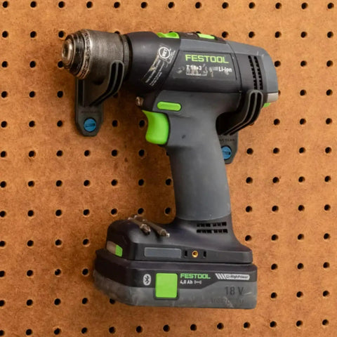Cordless drill mounted on steel pegboard from 16 Piece Pliers And Drivers Pegboard Hook Set With Heavy Duty Hooks And Screwdriver Rings.