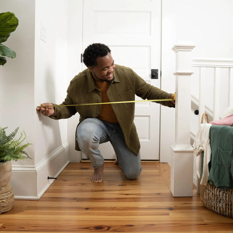 Man measuring banister height for Banister To Banister Gate Mounting Kit For Round Or Square Banisters Up To 37 Inches Tall.