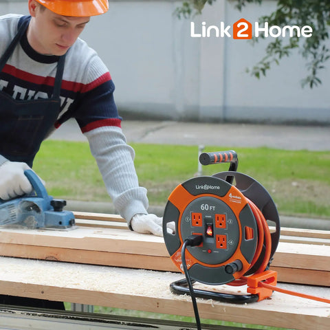 Worker using a saw near a 60 Ft Cord Reel With Four Outlets 14 AWG SJTW Cable Workhorse Heavy Duty Extension Cord Reel on a table.