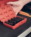 Hand holding a red case with Double Sided Lug Nut Socket Set Five Piece Half Inch Drive Flip Impact Sockets on black surface