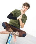 Person balancing on Slackhouse 3.0 Indoor Slackline Structure Built For Gym And Home Training with hands in prayer position.