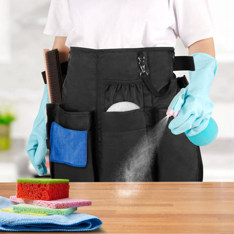 Person wearing Pro Grade Cleaning Apron With 9 Pockets And Adjustable Waist Belt For House And Hotel Jobs Durable Black Caddy Apron with cleaning tools.