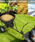 Heavy Duty Tow Behind Fertilizer And Seed Spreader With 130 Lb Hopper And Adjustable Flow Control For Even Coverage Up To 12 Ft Spread Width Perfect For Riding Mower Tractor Or ATV Use On Lawn And Garden attached to ATV on grass displaying year-round use.
