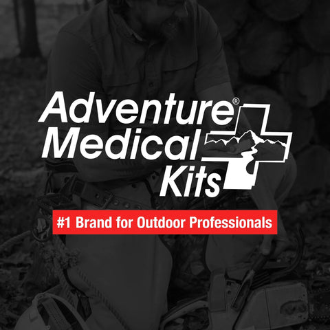 Adventure Medical Kits Trauma Pak first aid kit promo image; grayscale outdoors scene with logo overlay.