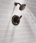 High End Lahara 14 Series Shower Trim Kit In Oil Rubbed Bronze, five spray settings, installed, water splashing.
