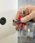 Hand holding Universal Construction Control Cabinet Key with plug in magnetic support near lock.