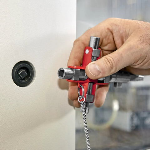 Hand holding Universal Construction Control Cabinet Key with plug in magnetic support near lock.