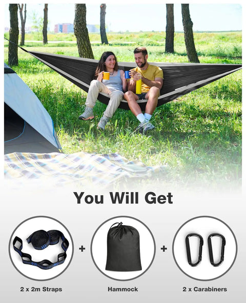 Couple relaxing in a Rugged Trail Ready Camping Hammock With Up To 700 Pound Capacity Includes 2 Tree Straps And Attached Carry Bag