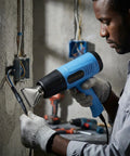 Man using Heat Gun With Dual Temperature 572 To 1112 Fahrenheit, Two Speed, 110 Volt, with nozzle on electrical work, blue.