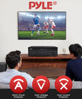 Two people watching soccer with 5.2 Channel Hi Fi Home Theater Receiver With 1000W Peak Power Wireless Bluetooth 4K Ultra HD Pass Through MP3 USB DAC Immersive Surround Sound Amplifier For Movie Nights And Party Vibes shown below TV.