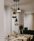 Three Light Modern Glass Pendant Chandelier for Dining Room and Kitchen Island with Amber Glass Shades hanging over a dining table.