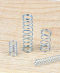 Everyday Versatile Tension And Compression Spring Wire Kit with zinc plated extension springs on wood surface