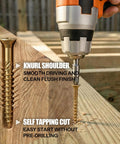 Self-tapping wood deck fasteners being drilled into wooden deck, showcasing knurl shoulder design and tan epoxy coating