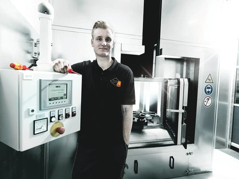 Person in a black uniform leaning on control panel of electrical equipment, representing use context for Six Piece Insulated Screwdriver Set With Lasertip Slotted And Phillips Tips For Electricians 10000 Volt Tested To 1000 Volt Working Standards Pro Grade Handles For Heavy Duty Electrical And Home Projects.
