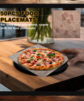 Hand placing pizza on tabletop with two pack 10.8 inch tabletop fire pit mats set for Solo Stove Mesa and Mesa XL heat resistant pine wood mats for outdoor fire pit includes 50 placemats in black displayed