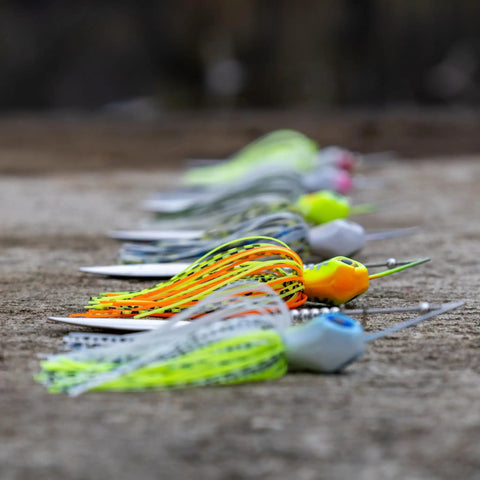 Side view of Spinner Bait Lure Half Ounce Tennessee Shad 3 Pack For Bass Trout Pike Salmon Walleye on ground.