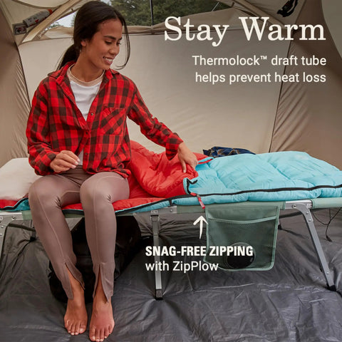 Woman sitting in a tent with Eco Warmth Sleeping Bag For Adults 30 40 50 Degree Fahrenheit Cool Weather, showing ZipPlow zipper.