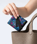Hand placing Silver Enhanced Pee Cloth For Women Hiking On The Go Travel Urinal Alternative into a tote bag