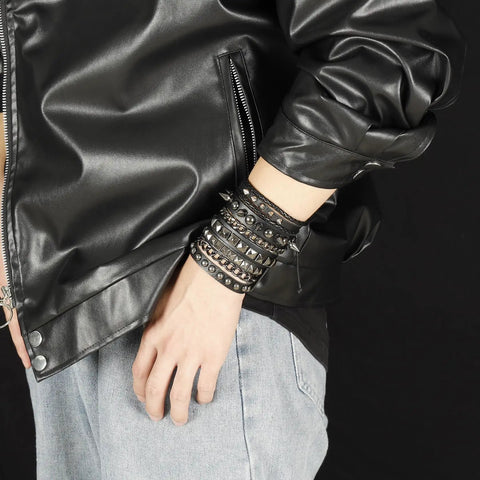 Badass 3 Piece Punk Gothic Leather Bracelet Set With Vintage Steampunk Spikes And Rivets Wide Adjustable Cuff Wristbands For Men And Women Daily Wear Gear worn stacked on wrist with black jacket.