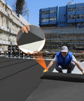 Worker installing Built Tough 51 Mil Epdm Rubber Roofing Rolls With Peel And Stick Backing on a flat surface.