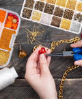Hands using Jewelry Findings Kit With 2880 Pieces Including Open Jump Rings, Lobster Clasps, Crimp Beads on DIY jewelry project