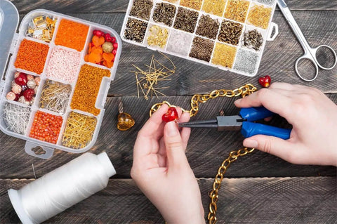 Hands using Jewelry Findings Kit With 2880 Pieces Including Open Jump Rings, Lobster Clasps, Crimp Beads on DIY jewelry project