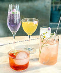 Cocktails on a table with Two Piece 12 Inch Stainless Steel Bar Spoon Set For Cocktails with Mirror Polished 18 8 Handle nearby