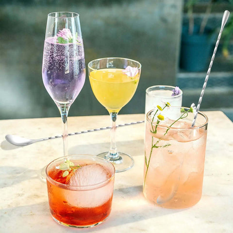 Cocktails on a table with Two Piece 12 Inch Stainless Steel Bar Spoon Set For Cocktails with Mirror Polished 18 8 Handle nearby