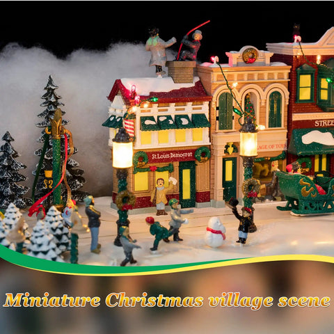 Miniature Christmas village scene with illuminated buildings and figures, featuring holiday decorations and snow-covered landscape