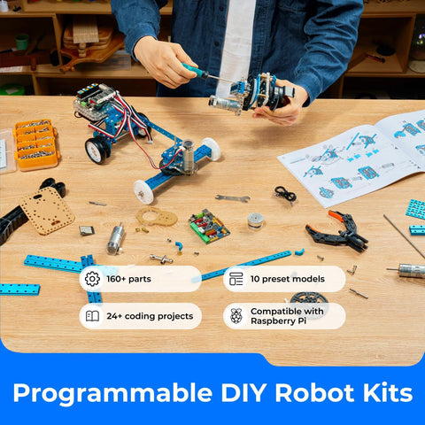 Makeblock mBot Ultimate robot kit parts spread on table: blue beams, wheels, motors, circuit board, screwdriver, manual.