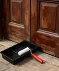 4 Inch Mini Paint Roller Kit With Tray For Gloss And Satin Finishes placed next to wooden doors, showing roller and tray details.