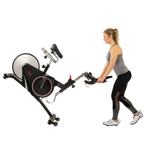 Woman adjusting the Smooth Riding Indoor Cycling Bike Featuring Forty Pound Rear Flywheel And Digital Console.
