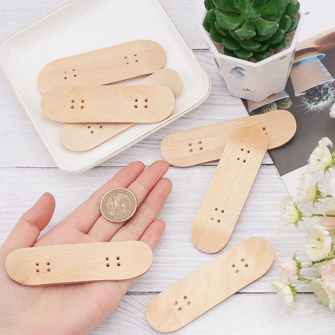 Hand holding 8 Pack Mini Fingerboard Set Maple Wood With Plastic Case Tiny Skateboards, showing size comparison with a coin.