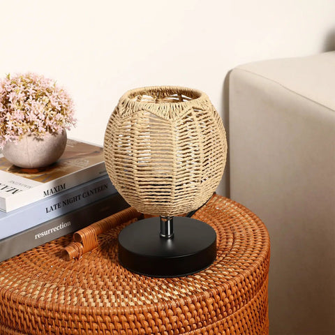 Three Pack Rattan Lamp Shades Vintage Boho Hanging Light Covers displayed on a wicker table next to a pink flower pot and books