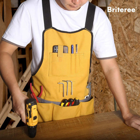 Person wearing a yellow durable canvas work apron with 21 tool pockets and handy magnetic holder, working with a power drill.