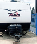 Dual 30Lb LP Propane Tank Cover For RVs And Travel Trailers Heavy Duty Black Plastic With Side Regulator Access Port And Individual Top Hatches Fits Two Tanks Easy Access For Camper And Recreational Vehicle installed on trailer.