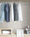 Taupe Forest Peel And Stick Wallpaper For Walls DIY Friendly Removable Self Adhesive Decor That Is Easy To Install And Remove With Damask Pattern 20.5 In X 18 Ft Roll Size shown behind clothing in a closet.