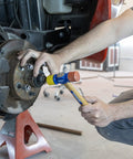 Mechanic using Soft Face Hammer With Two Faces Soft Red For Delicate Surfaces And Hard Yellow For Tough Jobs SF12 VN19410 on a car brake