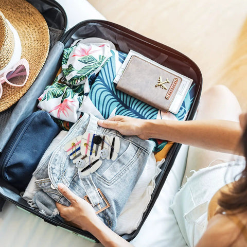 Woman packing a suitcase with On The Go Travel Sewing Kit With Needles, Threads, Buttons And Pins, Six Color Thread Sets, 100 Sets