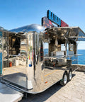 Kickass 10 Foot Stainless Steel Food Trailer Rocking A Slick Mirror Exterior And Completely Loaded Mobile Catering Kitchen by the seaside.
