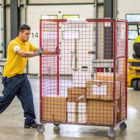 Worker pushing a cart with Heavy Duty 4 Inch Caster Wheels Set Of 4 With 1200 Lb Capacity in a warehouse environment.