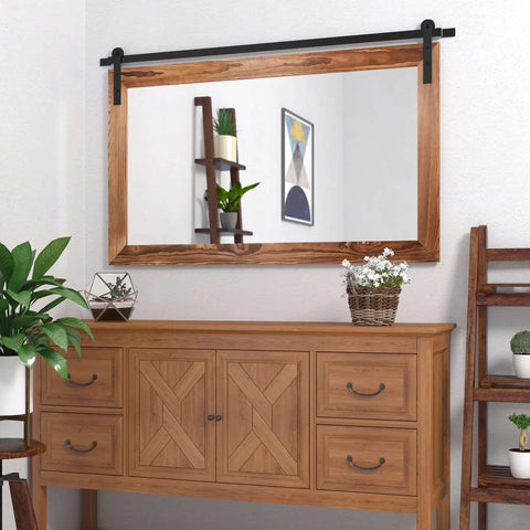Farmhouse Barn Door Mirror With Rustic Wood Frame 41 By 26 Inches in a living room setting, mounted above a wooden cabinet.